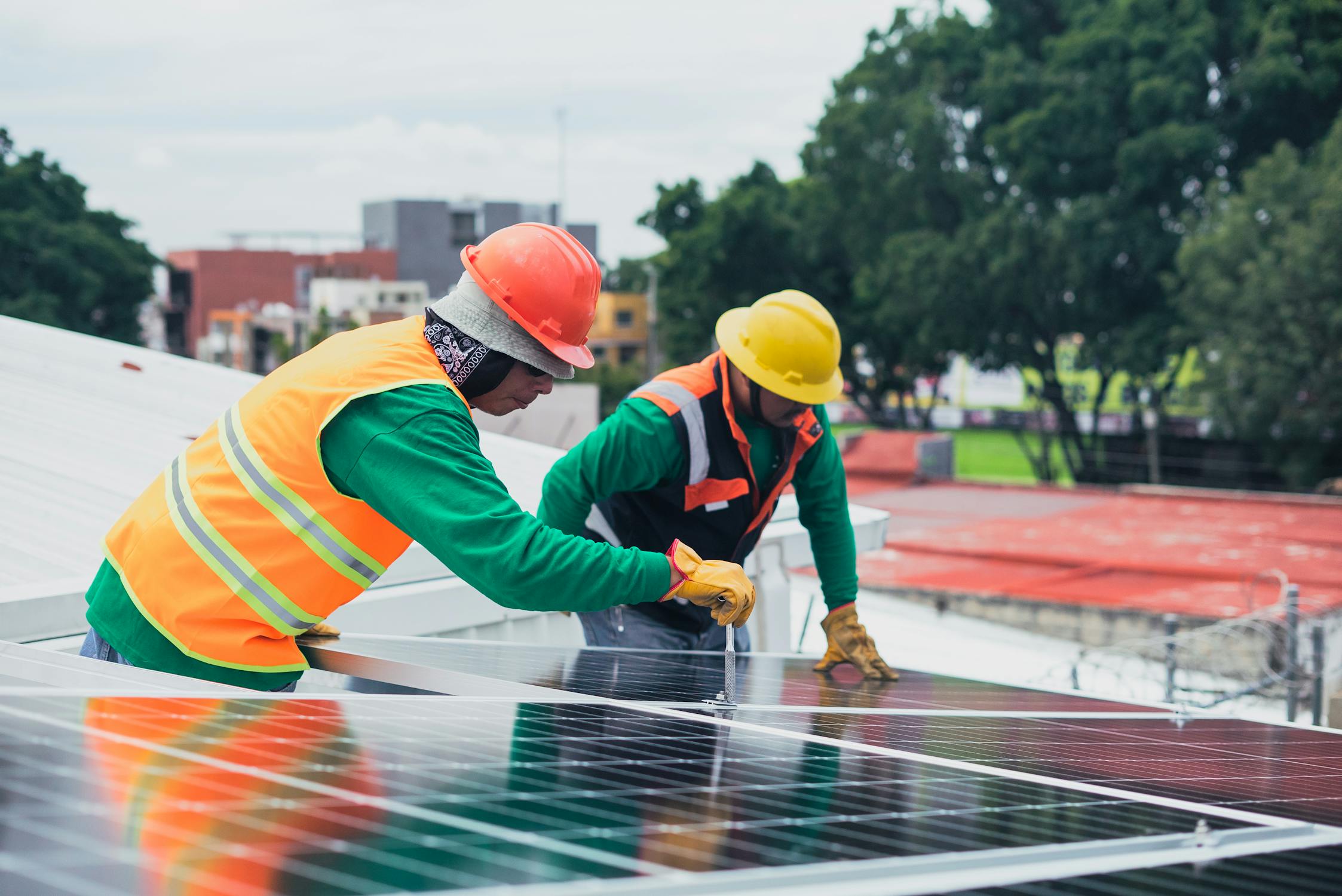 Technicians installing solar panels on residential roof